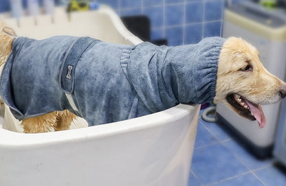 Dog sitting in a bathtub wearing the CottonCloud Absorbent Pet Bathrobe, staying warm and dry after a bath