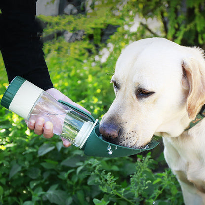 Dog drinking from the DualHydrate Portable Pet Dispenser during a hike